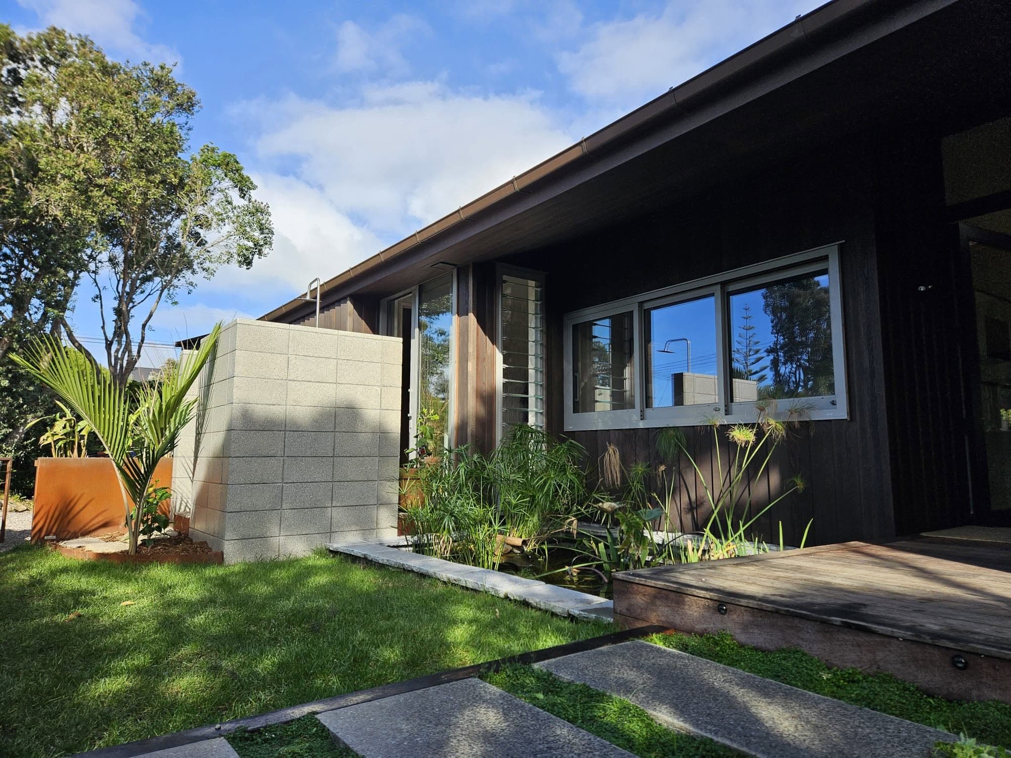 Modern dark-clad home exterior with landscaped garden