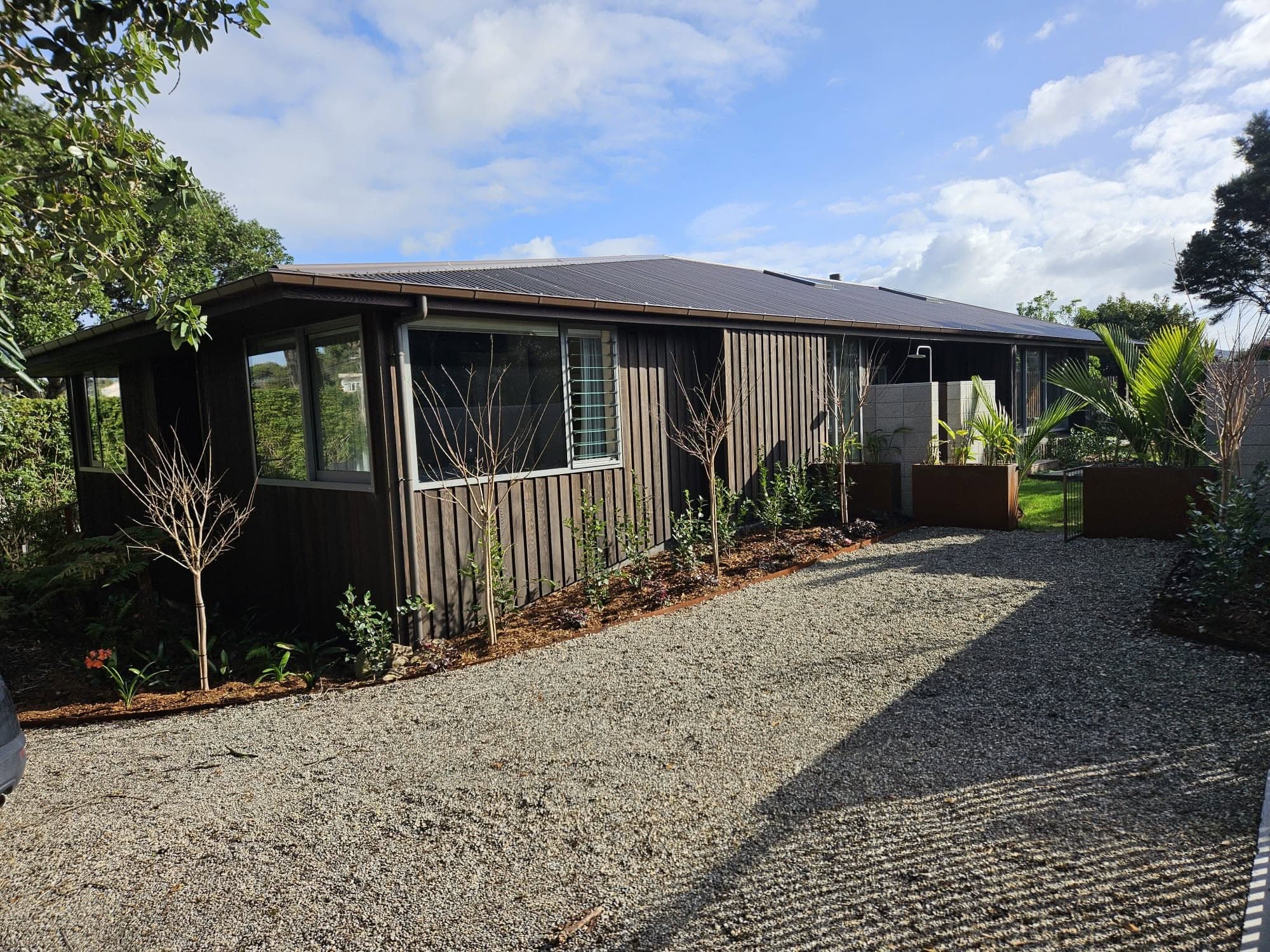 Finished home exterior with gravel driveway and landscaping